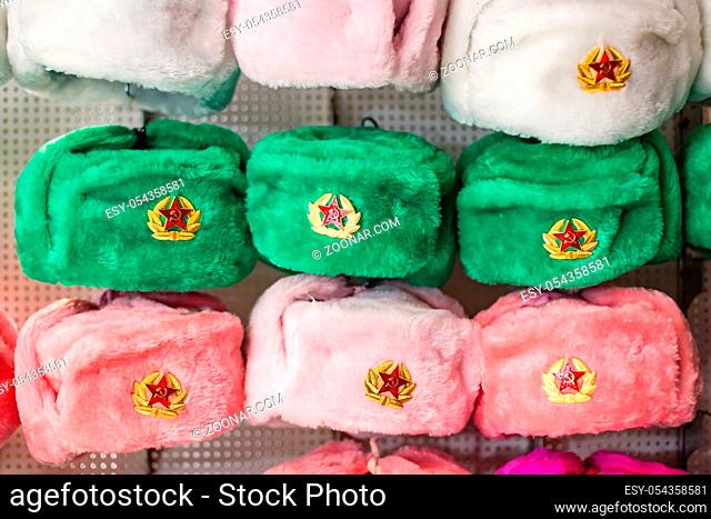 Moscow, Russia - November 27, 2019: Earflaps fur caps with red stars in a souvenir shop in Moscow. Winter hats, soviet and russian military uniform