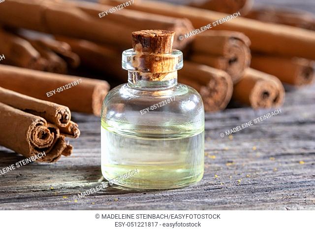A bottle of essential oil with Ceylon cinnamon sticks on a table