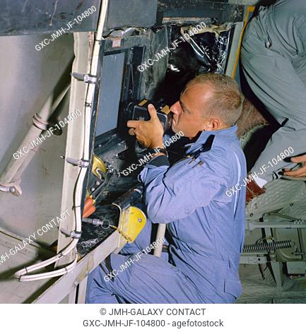 Astronaut Charles Conrad Jr., pilot for the prime crew on the Gemini-5 spaceflight, takes pictures of predetermined land areas during visual acuity experiments...