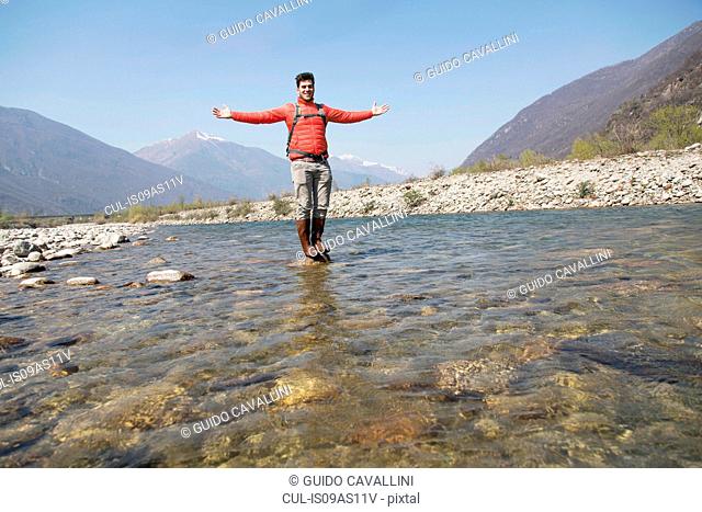 Portrait of young male hiker standing on Toce river rock, Vogogna, Verbania, Piemonte, Italy