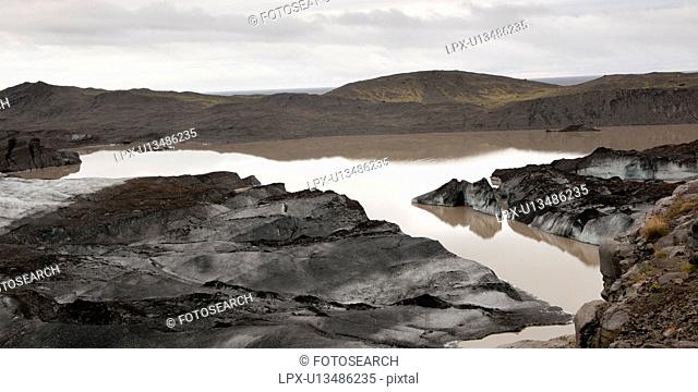 Dirty, muddy melting glaciers next to glacial lake