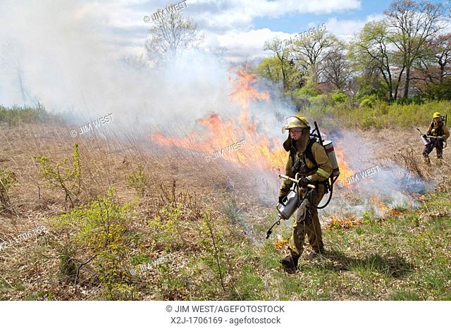 Detroit, Michigan - Woman wears protective clothing as she helps burn parts of River Rouge Park with the aim of eliminating invasive species  After the fire