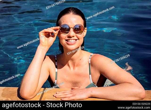 Portrait of woman with sunglasses in the pool