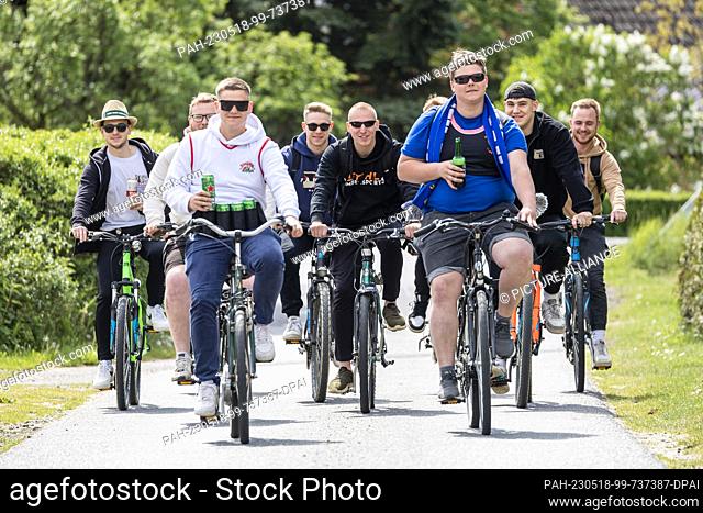 18 May 2023, Brandenburg, Bärenklau: On Ascension Day, young men go for a ride on their bicycles. Ascension Day is a church holiday celebrated on the 40th day...