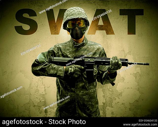 Uniformed armed soldier with damaged wall background