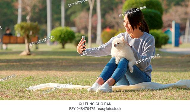 Woman taking selfie by mobile phone with her dog