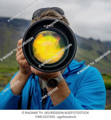 Photographer using a long lens to photograph near Seljalandsfoss Waterfall, South Coast, Iceland