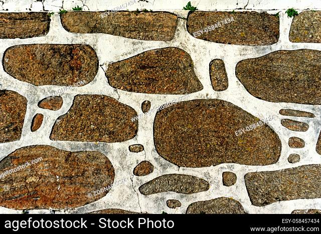 An abstract close up background of red granite rock and white plaster