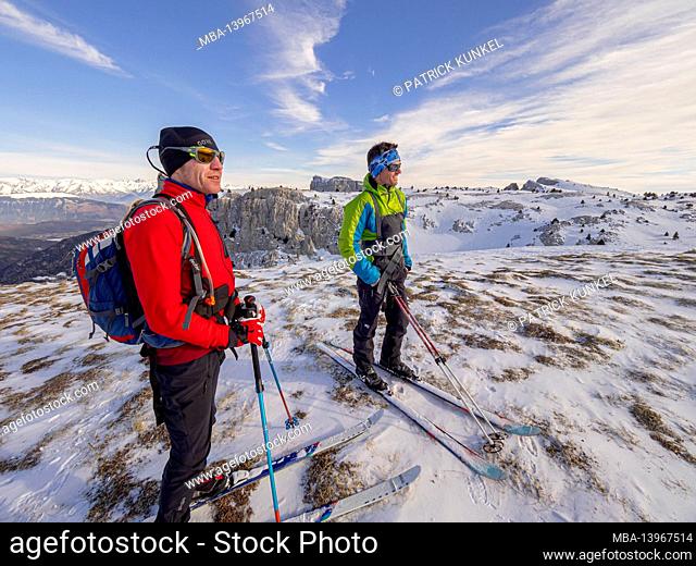 Two skiers on a ski tour with pulka material sledges through the nature reserve Réserve naturelle des Hauts Plateaux du Vercors