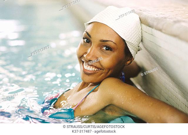 African american woman wearing bathing cap in indoor swiming pool