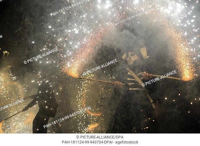 23 November 2018, Spain, Salvatierra: A disguised man dances in the middle of a ""firecracker inferno"" in the small town of Salvatierra