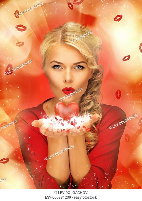 lovely woman in red dress blowing kisses on the palms of her hands