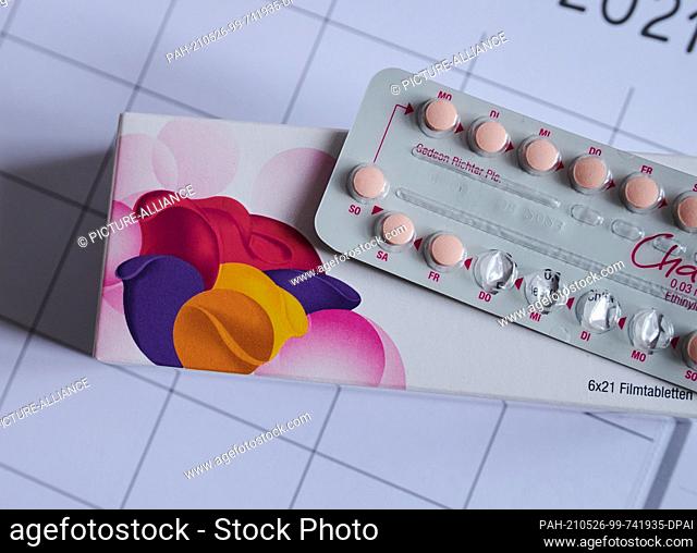 SYMBOL - 25 May 2021, Berlin: A partially opened monthly pack of the contraceptive pill lies on a calendar. The birth control pill was launched in Germany 60...