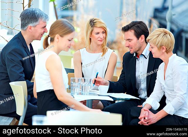 Business Team sitzt im Sommer draußen im Meeting