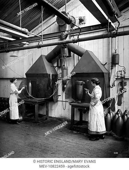 Cunard Shell Works, Bootle, Merseyside. Two female workers using spray guns to apply varnish or polish to the surface of completed heavy artillery shells