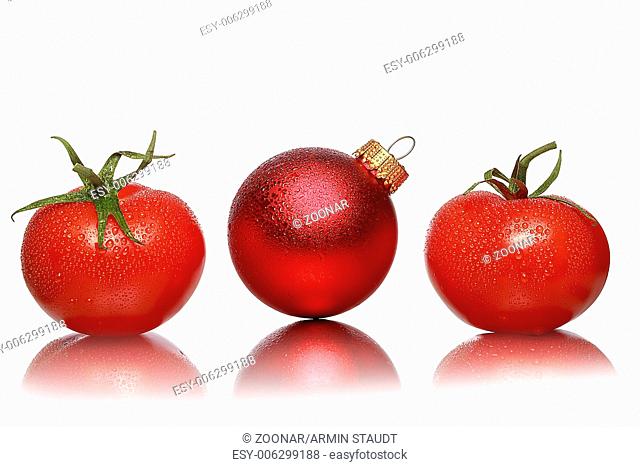 still life with two tomatoes and one red christmas ball, isolated on white