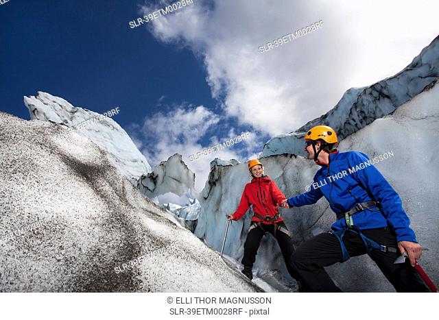 Hikers climbing on glacier