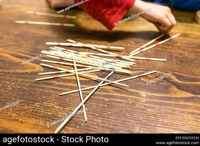 Children playing mikado on the table of the house