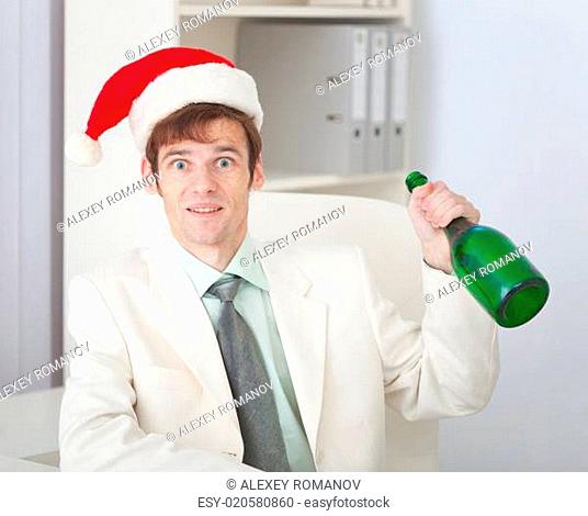 Businessman cheerfully celebrates Christmas at office