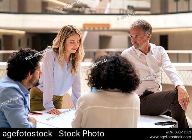 Multiracial business colleagues discussing strategy over document in meeting