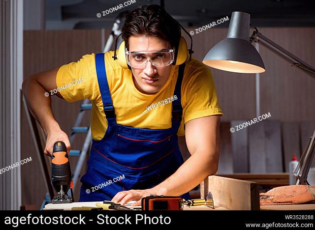 Worker working in repair workshop in woodworking concept