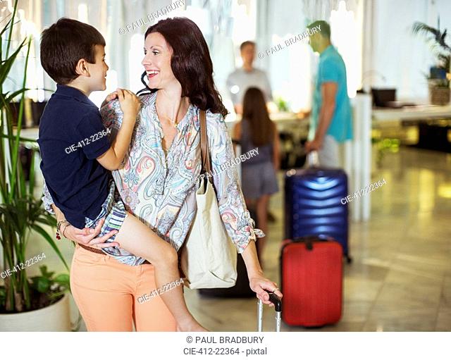 Mother carrying son in hotel lobby