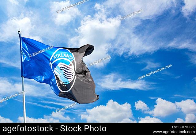 Atalanta flag waving against blue sky with white clouds. Space for text. Bergamo, ITALY - December 10, 2018