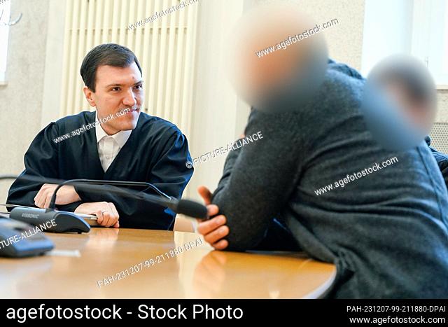 07 December 2023, Baden-Württemberg, Mannheim: Lawyer Timo van der Does (l) talks to the two defendants in the courtroom of the district court