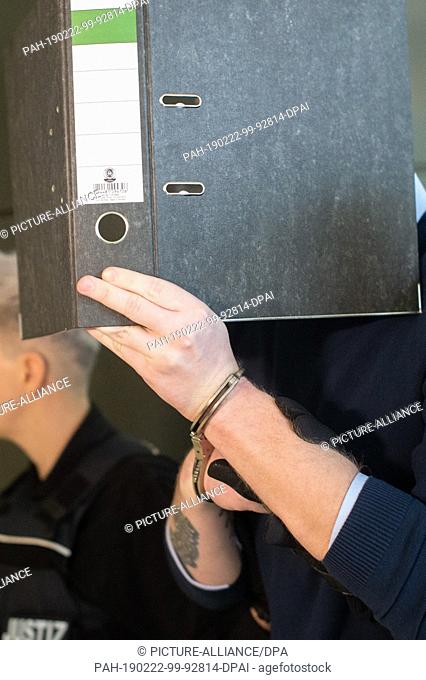22 February 2019, Saxony-Anhalt, Magdeburg: The accused is taken to the courtroom by a number of law enforcement officers