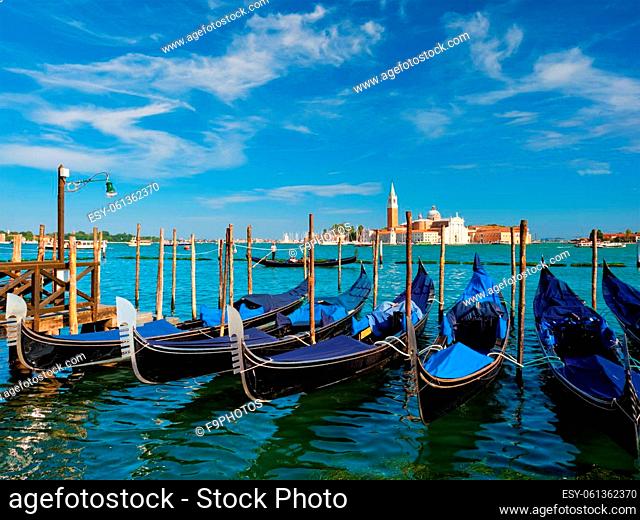 Gondolas and gondolier in lagoon of Venice by Saint Mark (San Marco) square with San Giorgio di Maggiore church in background in Venice, Italy