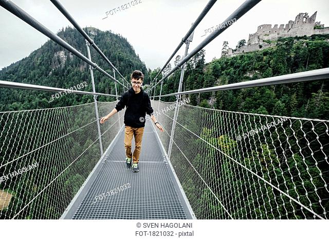 Teenage boy walking across Highline 179 suspension bridge, Tyrol, Austria
