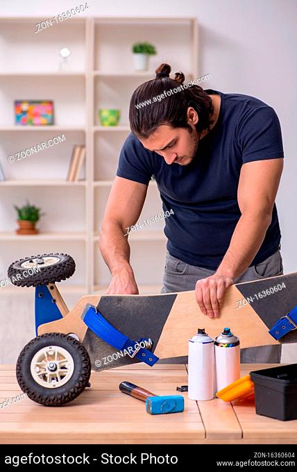 Young repairman repairing skateboard at workshop