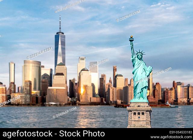 Statue of Liberty with background of New York city Manhattan skyline cityscape at sunset from New Jersey