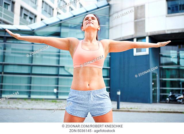 Sportliche Frau trainiert die freie Atmung in der Stadt