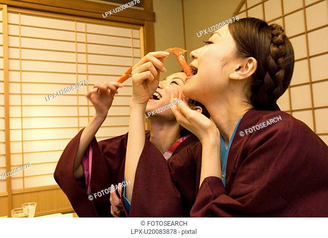 Women in yukatas eating seafood