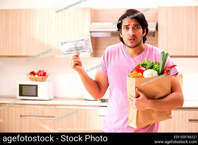 Young handsome man with vegetables in the kitchen
