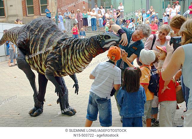 Children meet life-sized mobile dinosaur puppets at the Western Australian Museum, a street performance as part of the Perth Festival 2006