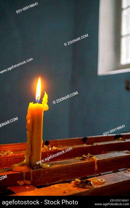 Burning candle at Koknese Evangelical Lutheran Church. Evangelic Lutheran Church in Koknese, Latvia. Interior of Koknese church
