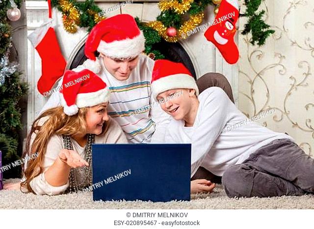 Family with notebook near Christmas tree