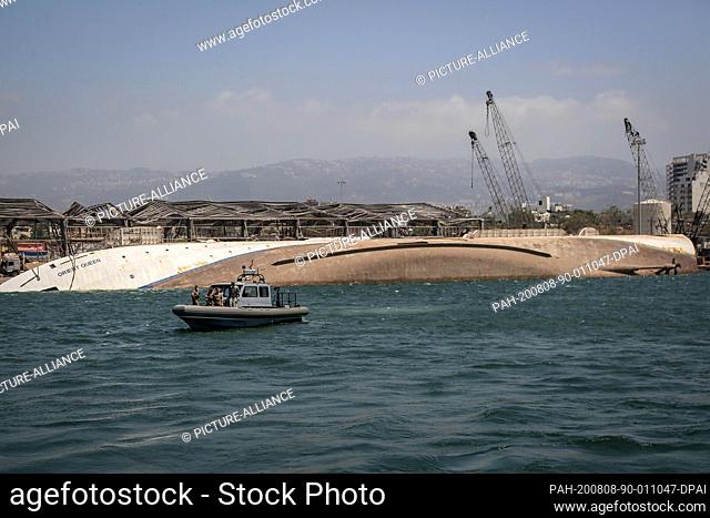 08 August 2020, Lebanon, Beirut: A Lebanese army speed boat sails in front of Orient Queen ship that sank after Tuesday's massive explosion in Beirut's port