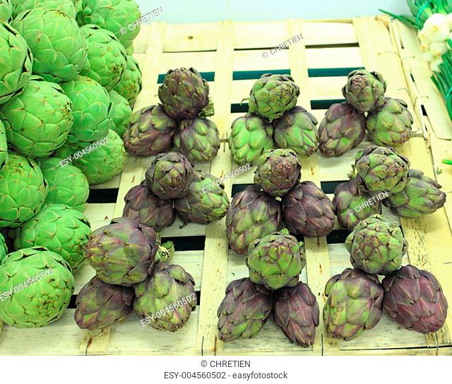 bunches of fresh artichokes on a market stall