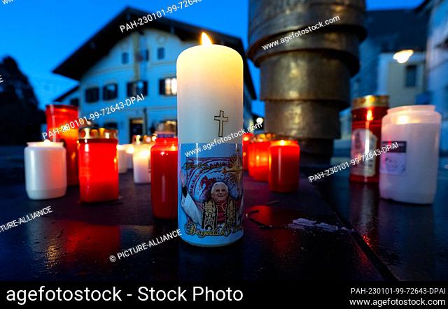 01 January 2023, Bavaria, Marktl: Candles stand in front of the birthplace of Pope Emeritus Benedict XVI. Pope Emeritus Benedict XVI died at the Vatican on Dec