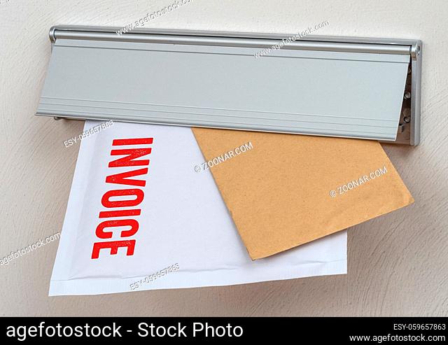 A letter labeled Invoice in a mail slot