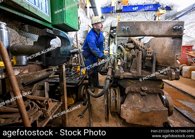PRODUCTION - 12 December 2023, Saxony, Bad Schlema: A miner maintains a shovel loader in the workshop underground at shaft 15 IIb of the Wismut mine