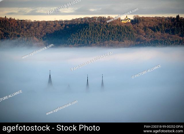 dpatop - 18 March 2023, Rhineland-Palatinate, Trier: The spires of Trier Cathedral and the Church of Our Lady rise out of the fog that lies over parts of the...
