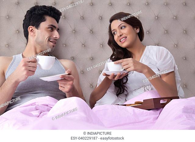 Couple having coffee in bed