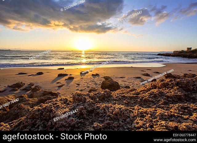 Landscape of rocky beach at sunset, El Buzo beach, Vistahermosa, Puerto de Santa Maria, Cadiz, Spain