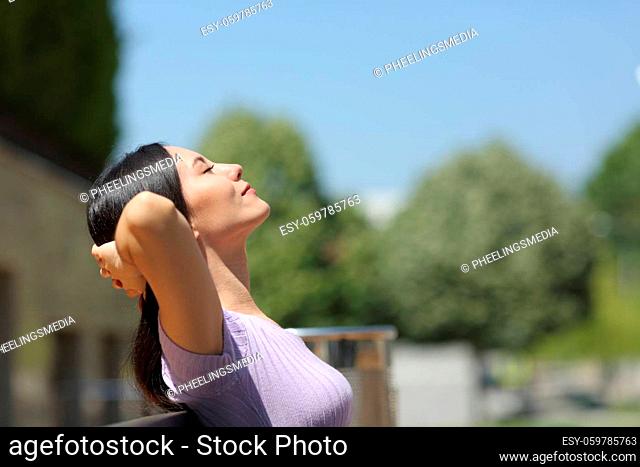 Asian woman resting sitting on a bench in a park