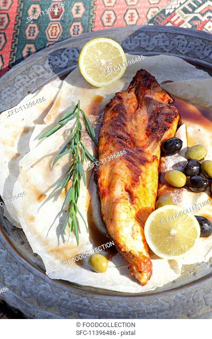 Grilled sturgeon with olives and lemon