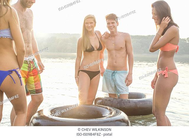 Friends having fun with inflatable ring in river